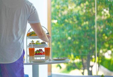 Masadaki ikindi çayından ellerimle atıştırmalık ve kek aldım.