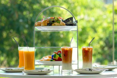 Bulanık yeşil ağaç arka planındaki masada ikindi çayı.