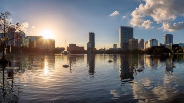 Gün batımında Orlando şehrinin panoramik manzarası Eola Gölü, Orlando, Florida, ABD 'deki çeşmeyle.