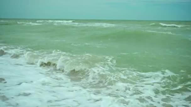 在阳光明媚的夏日刮风的日子里 在乌克兰阿佐夫海美丽的沙地空旷的海滩上 用波浪把慢动作的海浪拉近 背景美丽的山脉 — 图库视频影像