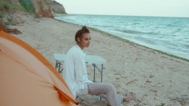Женщина Путешественница Сидит Оранжевой Палатки Наслаждается Жизнью Кемпинге Диком Пляже — стоковое видео