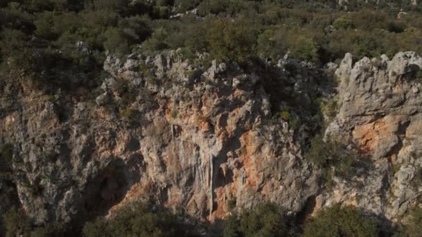 由强壮健壮的年轻人组成的无人驾驶飞机通过挑战攀岩路线爬上岩石墙的空中景观 攀登者靠在手上 手握粉笔 努力地攀爬 — 图库视频影像