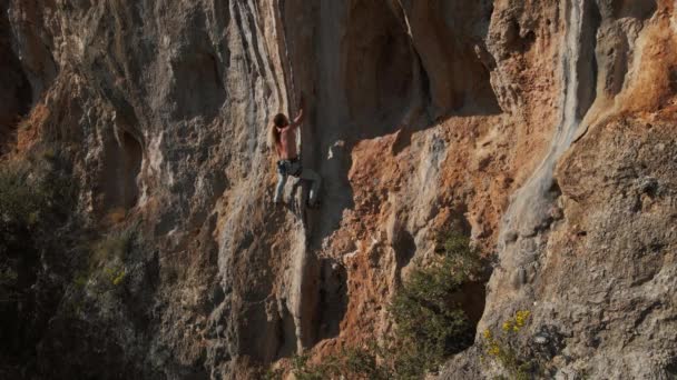 ドローンからの空中スローモーション撮影強い筋肉マンロッククライマー垂直崖の上に登ると ハード努力をし 握りを保持します トルコのロッククライミング ゲイリクバイリ — ストック動画