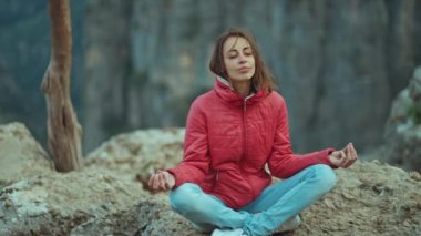 Güzel genç bir kadın, gün doğumunda dağların tepesinde ruhani yoga zen pozu veriyor. Yavaş çekimde, gündoğumunda Zen Zen Zirvesi. Türkiye 'nin Tazi kanyonunda yürüyüş