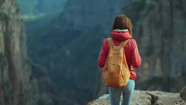 背着背包的女孩站在悬崖上 凝视着峡谷的悬崖峭壁 塔齐峡谷的观点 在土耳其 女性徒步旅行者过着健康的生活方式 积极参加暑期户外活动 — 图库视频影像