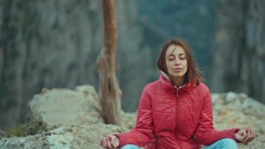 Güzel genç kadının portresini kapatmak için kamera hareketi. Yoga Zen pozu veriyor. Gün doğumunda dağların tepesinde, yavaş çekimde, gün doğumunda Zen Zen Zirvesi. Türkiye 'nin Tazi kanyonunda yürüyüş