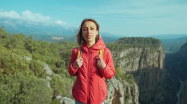 Tazy Kanyonu 'na bak. Kız ayakta duruyor ve dağlardaki çarpıcı manzaraya hayran kalıyor. Kırmızı ceketli bir turist kadın uçurumun kenarında yürüyüş yapıyor. Muhteşem Tazi Kanyonu, Türkiye. Tazı Kanyonu