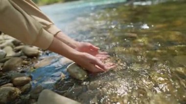 Ağır çekimde kadın elleri, Mountain River 'ın palmiyelerinden taze soğuk temiz su alıyor. Geniş açı, avuç içlerine odaklan. Temiz ve güvenli yatırım konsepti. Su kaynakları, toprak, çevre