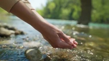 Ağır çekimde kadın elleri, Mountain River 'ın palmiyelerinden taze soğuk temiz su alıyor. Geniş açı, avuç içlerine odaklan. Temiz ve güvenli yatırım konsepti. Su kaynakları, toprak, çevre