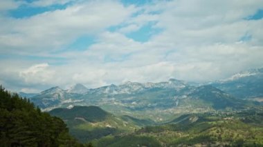 Dağ sırtı, dağlık çayırlar, bulutlu, dramatik gökyüzü ve ön plandaki ağaçlarla çarpıcı bir dağ manzarası. Türkiye 'de doğanın panoramik görüntüleri.