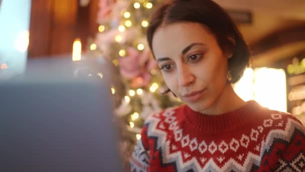 Laptopla Çalışan Sıradan Güzel Bir Kadın Kafeteryada Oturmuş Noel Süslemeleri — Stok video