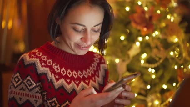 Closeup Cute Smiling Woman Red Festive Sweater Background Lights Christmas — Vídeo de Stock