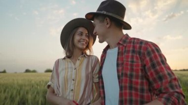 4k slow motion of happy patriotic couple celebrating fourth of july with national flag in rural lardmark at sunset. Federal holiday. 4 July Independence day celebrating with national American flag