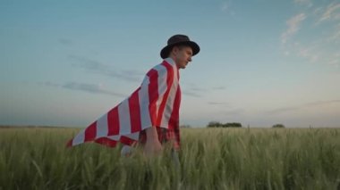 man walking with American flag. 4 of July, Independence day celebration. Slow-motion wide angle ground view camera following. side view. Patriotic holiday, democracy and veteran respect conept