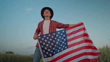 man walking with American flag. 4 of July, Independence day celebration. Slow-motion wide angle ground view camera following. front view. Patriotic holiday, democracy and veteran respect conept