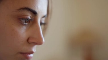 extreme close up portrait woman eyes. girl sits at home on couch with laptop, working remotely, shopping online. laptop screen reflects in womans eyes
