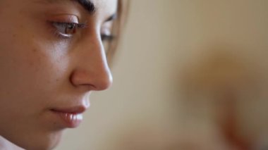 extreme close up portrait woman eyes. girl sits at home on couch with laptop, working remotely, shopping online. laptop screen reflects in womans eyes