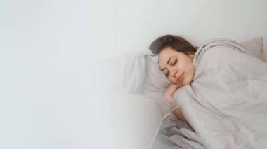 young woman lies alone on bed at home, cold and sick. illness, cold, virus, doctors call at home, consultation with a doctor by phone