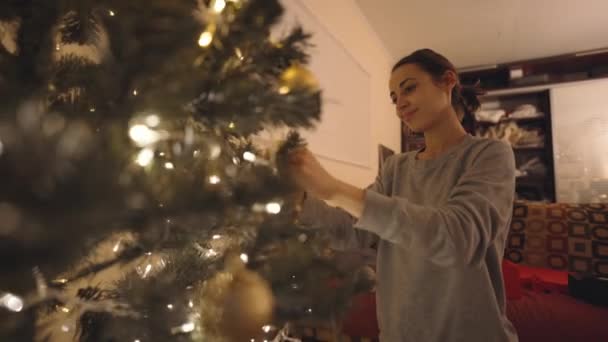 Beautiful Smiling Woman Decorates Christmas Tree Home Bulbs Making Nice — ストック動画