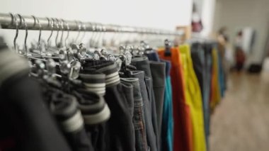 Dükkandaki tezgahın üzerinde parlak spor kıyafetleri asılı. Spor kıyafetleri, seçici odak