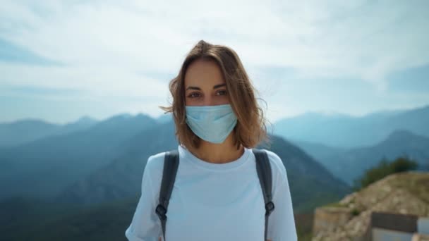 코로나 바이러스가 유행하는 여행하는 여자는 얼굴에 마스크를 산꼭대기 희망을 기다리고 — 비디오