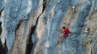 muscular man climber makes hard effort, falls and breaks down on the route. brave and strong man. climbing belaying and insurance.