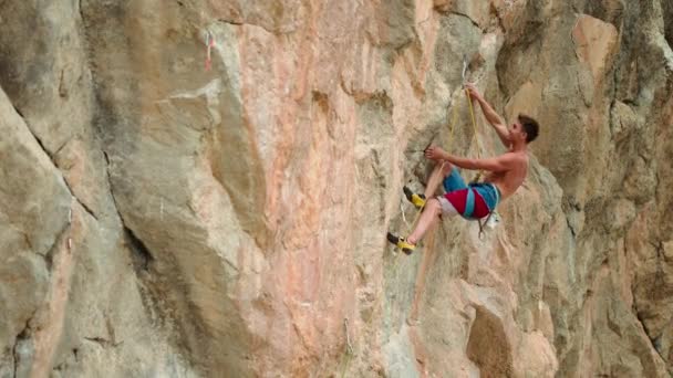 慢动作适合和专注的运动员爬上具有挑战性的路线在高耸的悬崖上 肌肉发达 体格强健 英俊的登山者在户外岩石上攀爬 — 图库视频影像