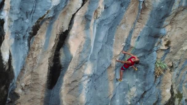 ロッククライマーが岩に登る 強い男は困難な道を克服する 自然界のリラックスと自由 スポーツマンはハードルート上で登る スローモーション4K — ストック動画