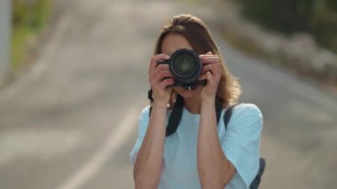 pretty woman travel blogger taking photo or video on professional camera, viewpoint among mountains and blue sky, cableway on background. viewpoint of Tunektepe Teleferik, Antalya, Turkey