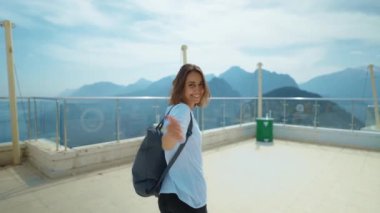 treking camera shot traveler freedom woman with backpack walking at view point on mountain top and enjoying mountains view, summer journey vacation. upper station of cable way in Antalya, Turkey