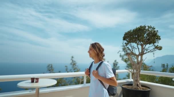 観光客の旅行者は テキストのための青い背景の谷の風景を表示するモックアップを表示するプラットフォームに立っている 山から海とアンタルヤ市への景色を楽しむカジュアルな服のヒップスターの若い女の子 — ストック動画