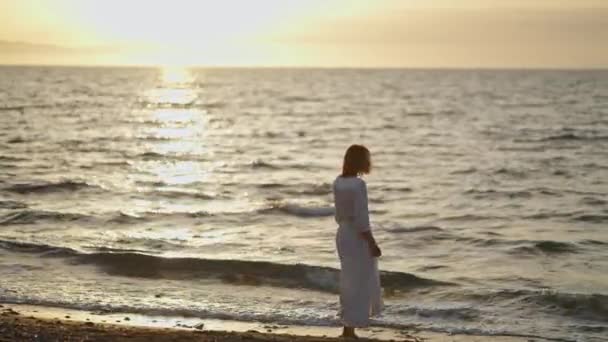 Женщина Элегантном Длинном Белом Платье Гуляет Морскому Пляжу Время Оранжевого — стоковое видео