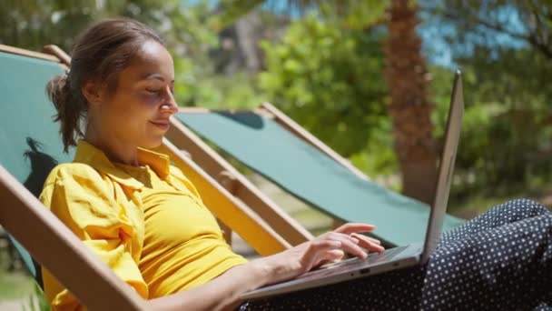 Seitenansicht Fernbedienung Online Arbeitende Frau Sitzt Auf Sonnenliege Mit Palmen — Stockvideo