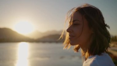 Portrait smiling natural beauty woman looking to camera, enjoying sunset landscape with mountains