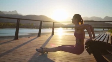 Güzel Enerjik Fitness Kızı şınav çekiyor. Harika bir dağ manzarası olan bir açık hava terasında egzersiz yapıyor. Nehir kıyısında Sunset Sunlight 'la Akşam Görüntüleri