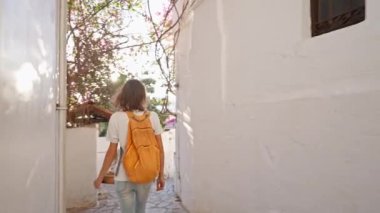 Sırt çantalı, gülümseyen güzel turist kadın turist şehrin eski turistik bölgesinde boş bir sokakta yürüyor ve Türkiye 'nin Marmaris kentinde tatilin tadını çıkarıyor. Popüler turizm merkezini gezmek