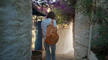 Sırt çantalı, gülümseyen güzel turist kadın turist şehrin eski turistik bölgesinde boş bir sokakta yürüyor ve Türkiye 'nin Marmaris kentinde tatilin tadını çıkarıyor. Popüler turizm merkezini gezmek