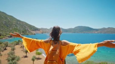 Turuncu elbiseli çekici, ince, bronz tenli kadın gezgin turkuaz suyu ve cennet boş deniz plajı olan güzel körfezin kıyısında duruyor. Türkiye 'de kız deniz kıyısında yürüyor,