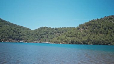 Sırt çantalı çekici, ince kadın gezgin turkuvaz suyu ve cennet gibi boş deniz plajlarıyla güzel bir deniz koyunda yürüyor. Ağır çekim 4k, Türkiye 'de seyahat