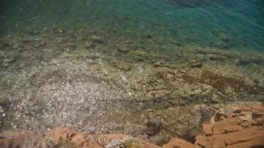 Türkiye kıyılarındaki güzel Akdeniz kıyılarının panoramik manzarası. Plajda turkuaz su ve kayalar var. Güneşli yaz gününde muhteşem bir cennet körfezi