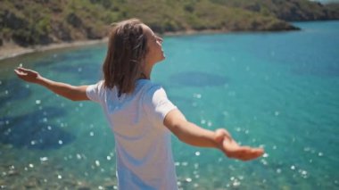 Sırt çantalı çekici, ince kadın gezgin turkuvaz suyu ve cennet gibi boş deniz plajlarıyla güzel bir deniz koyunda yürüyor. Ağır çekim 4k, Türkiye 'de seyahat