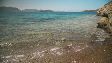 Sırt çantalı çekici, ince kadın gezgin turkuvaz suyu ve cennet gibi boş deniz plajlarıyla güzel bir deniz koyunda yürüyor. Ağır çekim 4k, Türkiye 'de seyahat