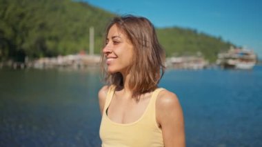 Güzel, ince, sportif kadın gezgin, sakin turkuaz su ve cennet gibi boş deniz plajlarıyla güzel deniz koyunun kayalık sahillerinde yürüyor. Yavaş çekim 4k, Türkiye 'nin batısında yaz seyahati