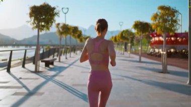 Park parkındaki Bridge Road 'da koşan kadın koşucu. Tepe manzaralı. Vücut geliştiren kız spor koşucusu sağlık konsepti...