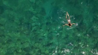 Bikini mayo giymiş genç bir kadının mercan resifinde denizde rahatlamasını gösteren hava manzarası. Mutlu ada yaşam tarzı. Cennet 'te tatil. Okyanus rahatlaması, Tayland 'a seyahat