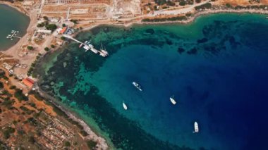 Yukarıdan bakıldığında, şeffaf ve turkuaz deniz manzaralı birkaç tekne ve yatla. Akdeniz kıyıları, Knidos Antik kenti, Datca, Türkiye. Yaz tatili ve deniz kenarına seyahat