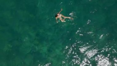 Bikini mayo giymiş genç bir kadının mercan resifinde denizde rahatlamasını gösteren hava manzarası. Mutlu ada yaşam tarzı. Cennet 'te tatil. Okyanus rahatlaması, Tayland 'a seyahat