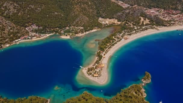 オルデニス Oludeniz トルコ南西部のリゾート村である Oludeniz Tabiat Parkiと広く白いBelcekiz Beachの青いラグーンで知られています — ストック動画