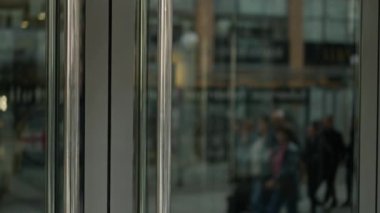 Genç iş adamı iş merkezinden çıkıyor. Beyaz tenli yakışıklı girişimci modern ofis binasının kapısından içeri giriyor.