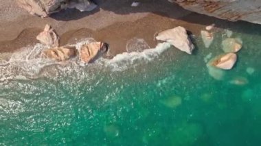 Antalya, Kas, Türkiye yakınlarındaki Turkuaz Sahili 'nde kırılan dalgalar ve gizli sahil şeridi boyunca kuş bakışı görüntüler. 4k, 25Fps 'te.